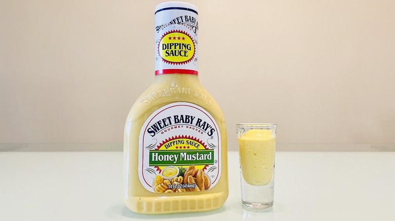 Bottle of Sweet Baby Ray's Honey Mustard Dipping Sauce with small serving on side