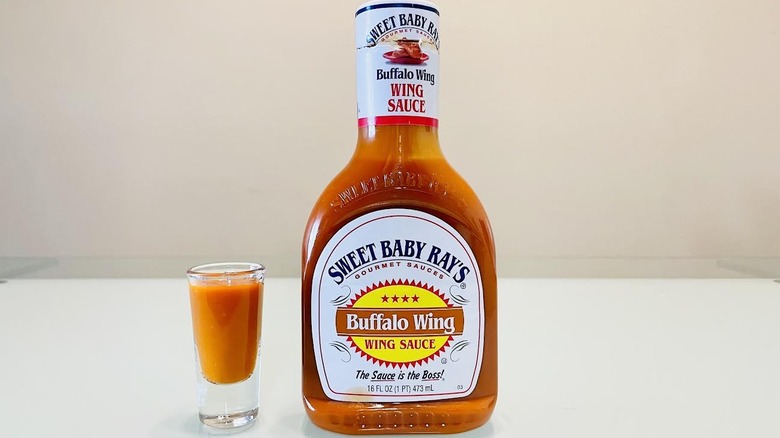 Bottle of Sweet Baby Ray's Buffalo Wing Sauce with small dish on side
