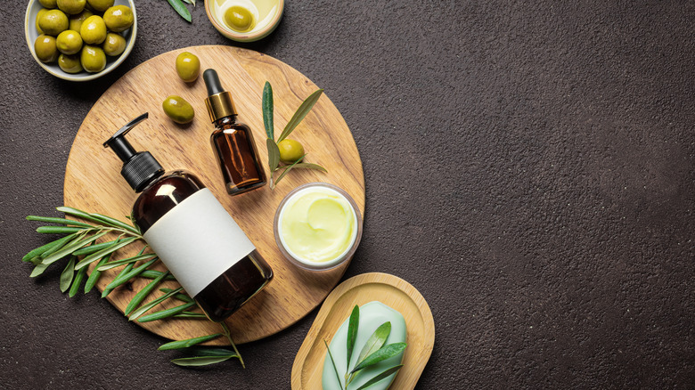 Olive oil products arranged on a wooden board.