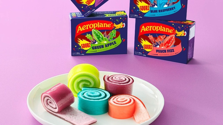A plate of Aeroplane jelly roll-ups beside boxes of Aeroplane jelly mix