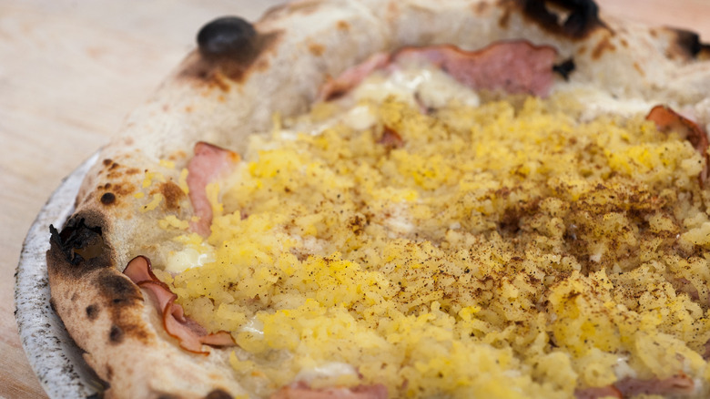 White sauce on a pizza with yellow topping