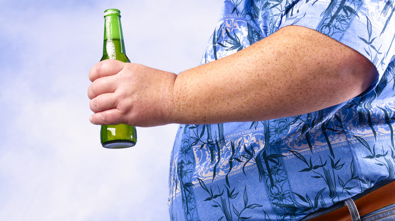 Fat man holding a beer