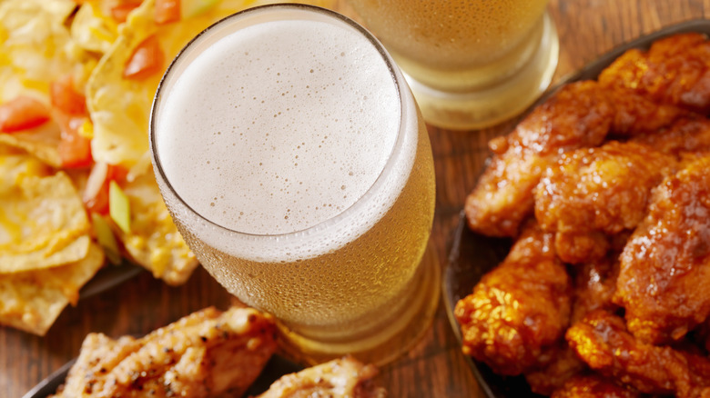 Glass of beer with wings and nachos