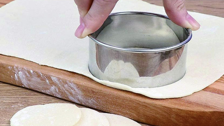 A man cutting biscuits out of dough