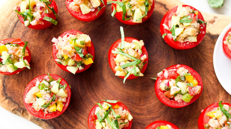 Bite-sized panzanella stuffed tomatoes on serving board