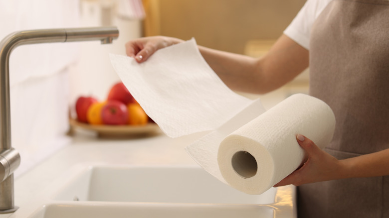 Woman ripping off paper towel sheet