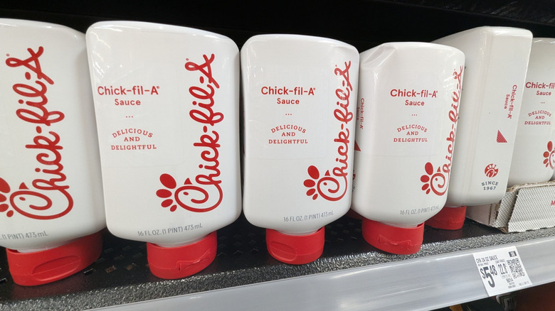 Bottles of Chick-Fil-A Sauce on a shelf in a grocery store