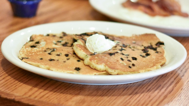 A white plate with chocolate chip pancakes and butter