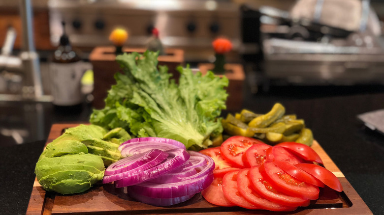 Fresh burger toppings on a cutting board