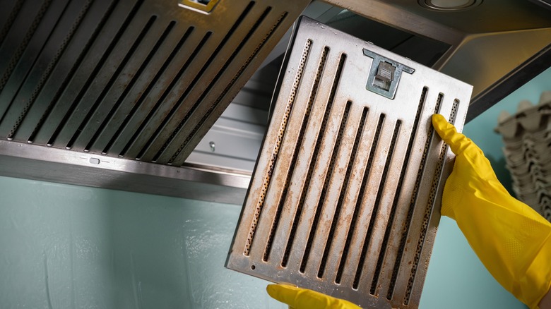 Person removing dirty cooker hood filter