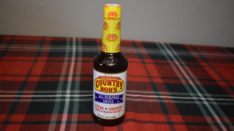 small dark bottle with yellow top, white and yellow label
