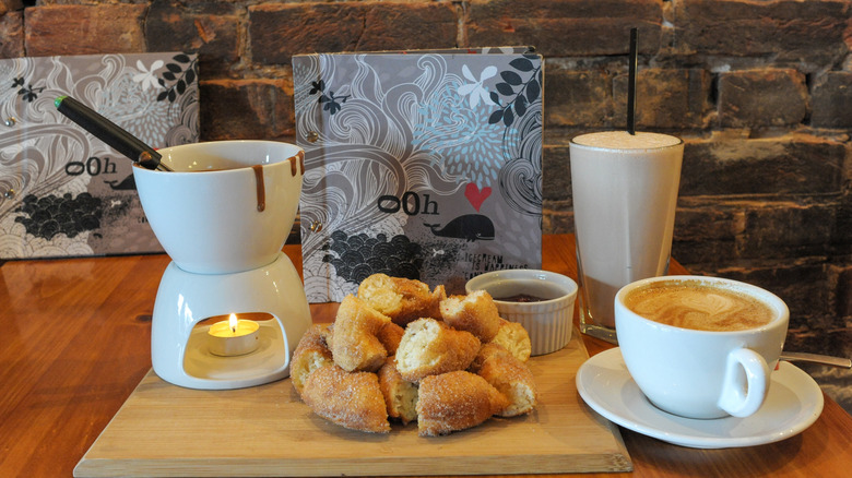 Chocolate fondue setup with sliced donuts