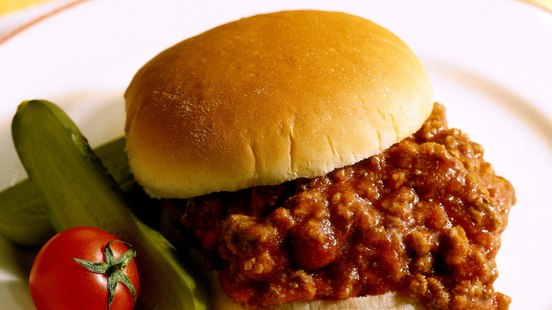 A sloppy joe on a plate with veggies