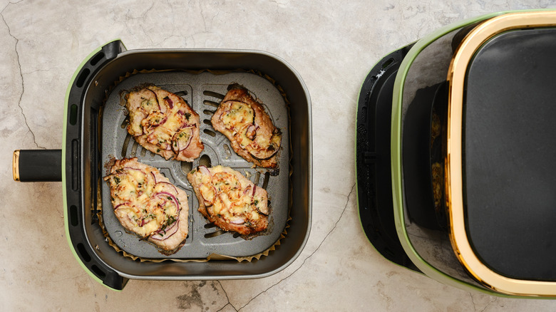 Air fryer with small pork chops in the basket