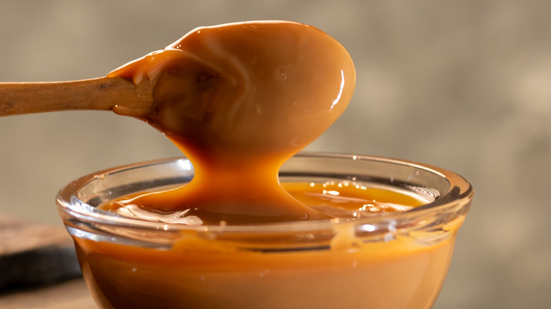 Glass bowl of dulce de leche and spoon