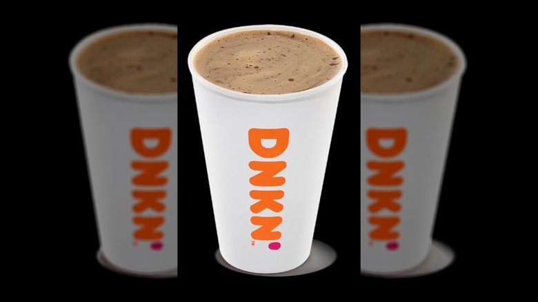 A cup of a hot Dunkaccino against a black background