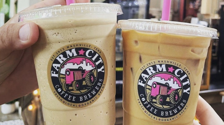 Two happy caffeinated customers holding drinks