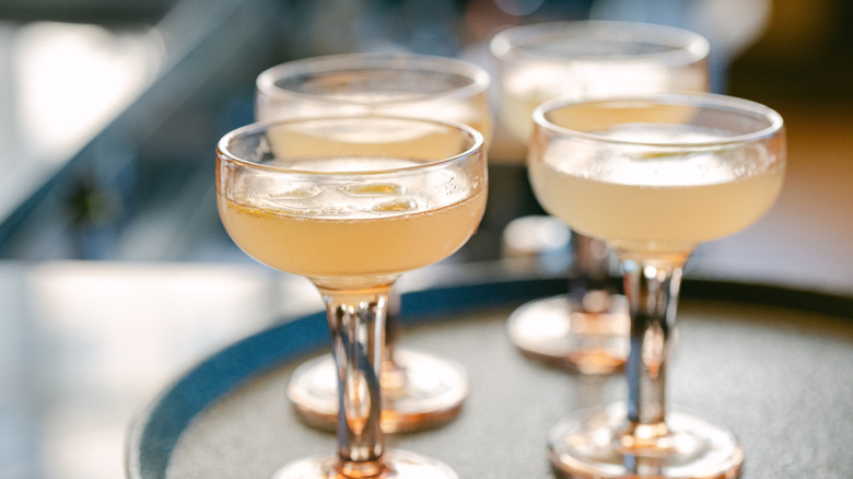 Four French 75 cocktails on serving platter