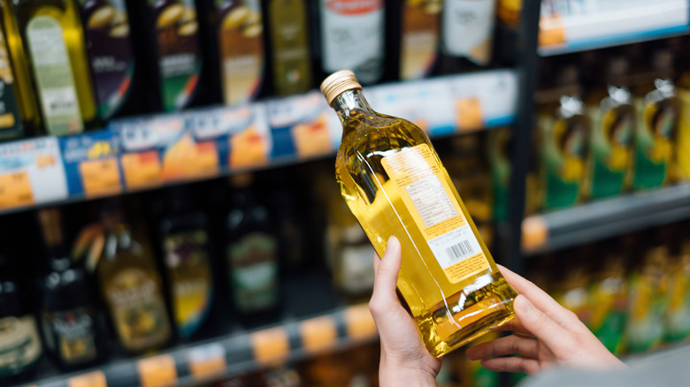 Hands holding bottle of cooking oil