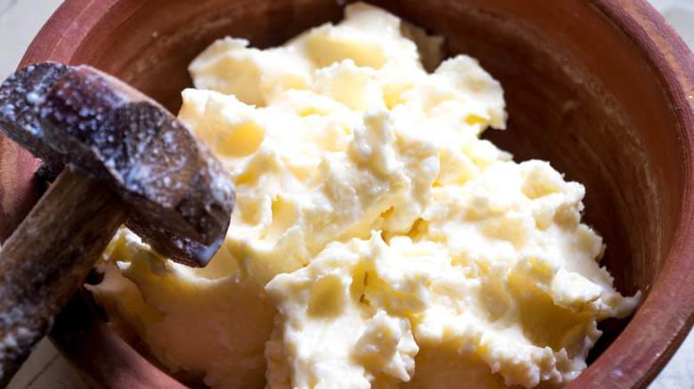 A rustic bowl of homemade butter is seen in closeup.