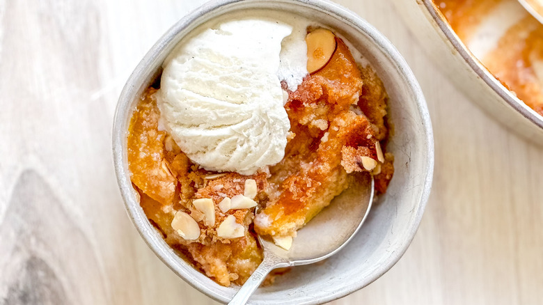 Gluten-free peach cobbler in bowl with vanilla ice cream