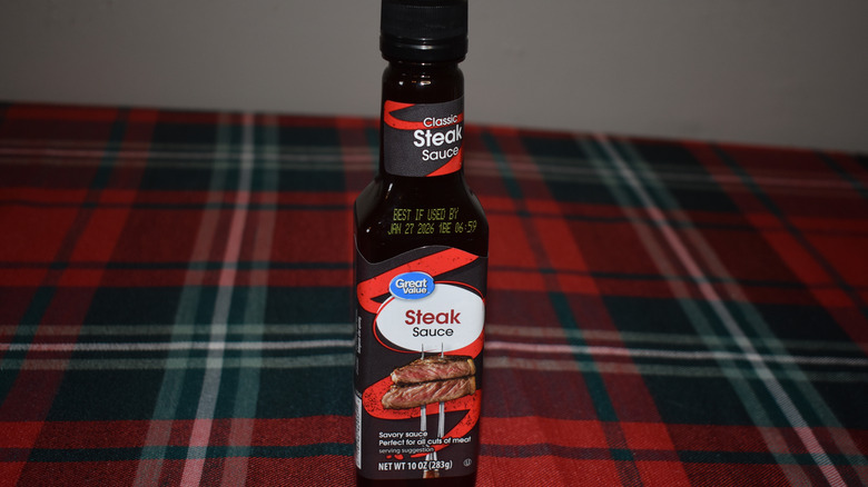 a black, red, and white bottle of sauce
