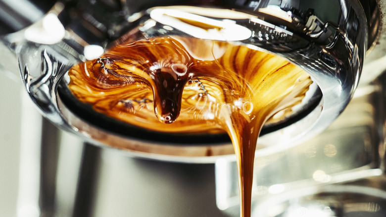 An espresso machine extracting a shot from ground coffee