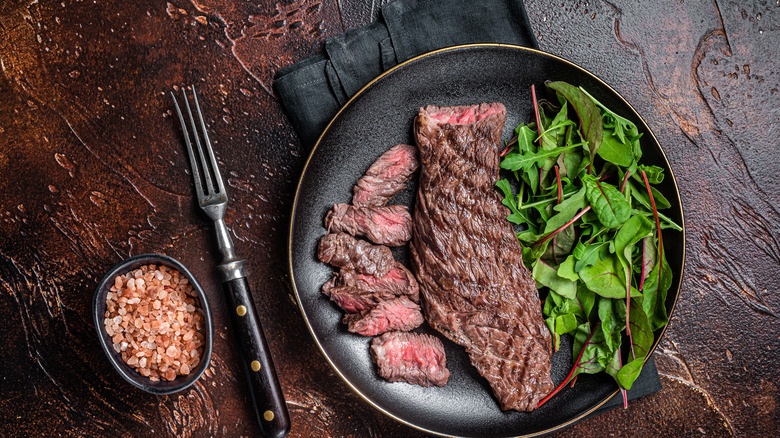 Partially sliced steak and salad
