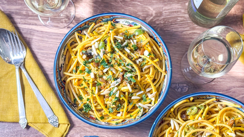 High-protein pasta con le sarde (with sardines) in bowls on table with white wine
