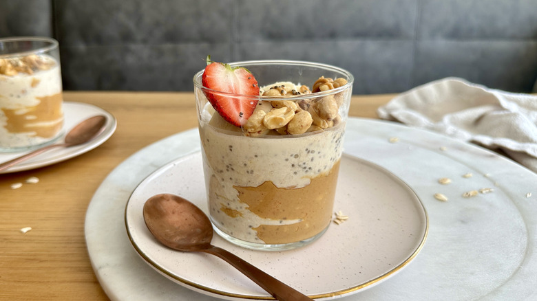 Jar of overnight oats with peanuts and strawberry slice