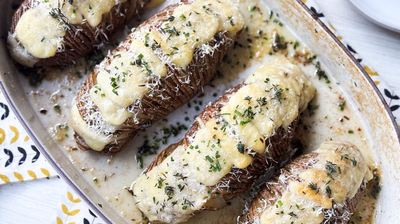 Extra cheesy Hasselback potatoes in casserole dish close up