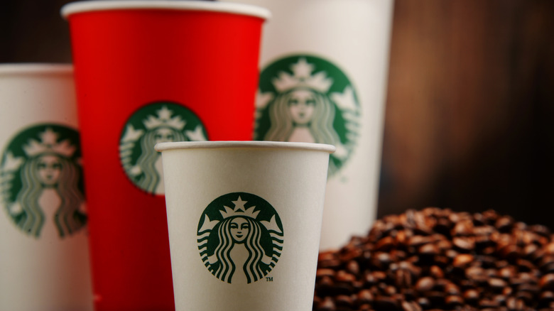 Four sizes of Starbucks cups with coffee beans