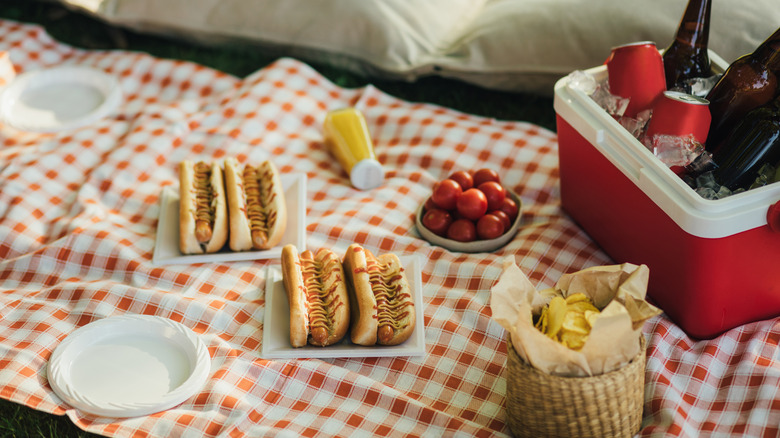 A picnic spread with hot dogs on a blanket
