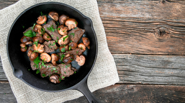 Steak tips with mushrooms in cast iron pan