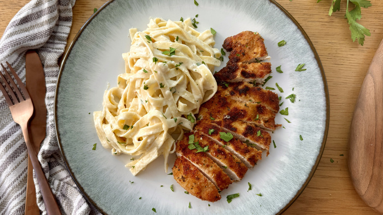 Fettuccine Alfredo and sliced chicken on plate