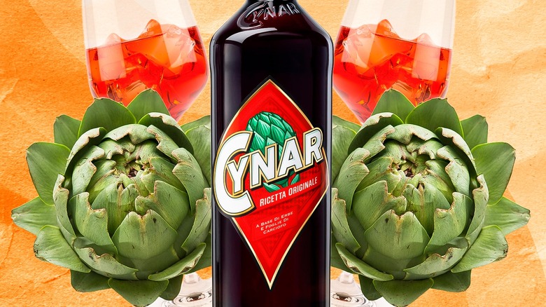 Bottle of Cynar beside artichoke vegetables with glasses in the background