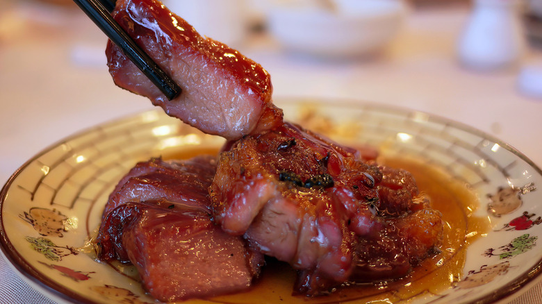 Chinese barbecue pork in a dish with chopsticks