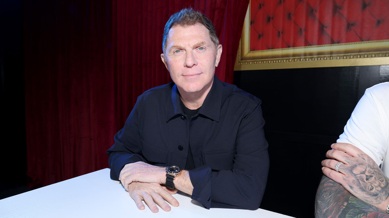 Bobby Flay sitting at a white table