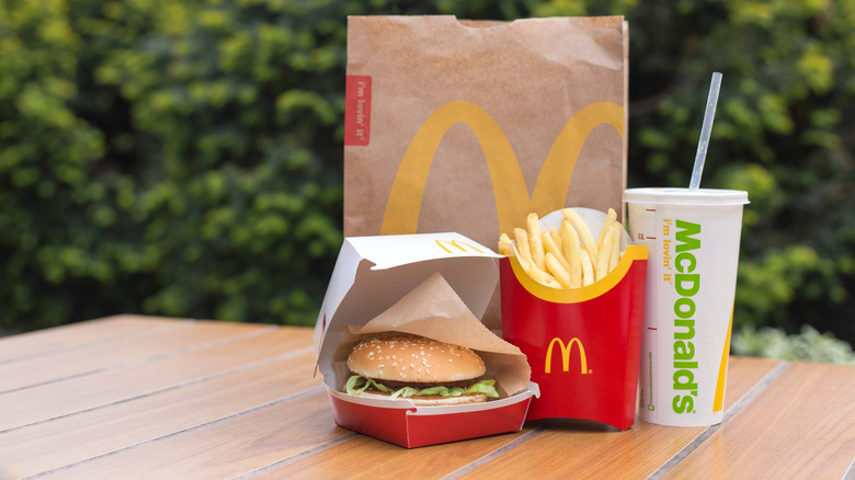 A Big Mac combo meal sits on a wooden table outdoors.