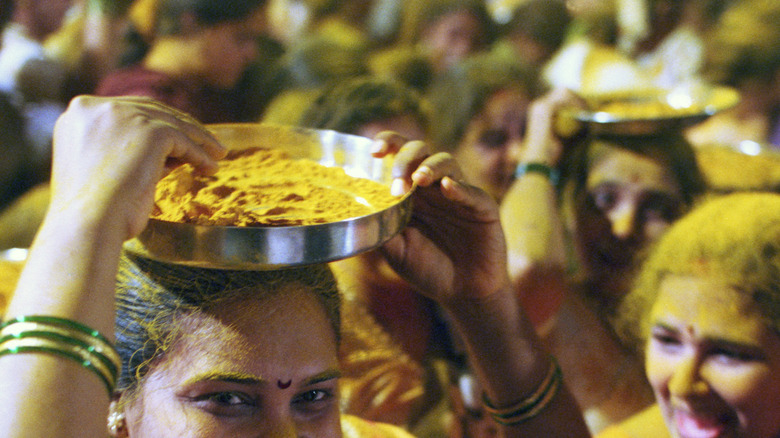 Indian revelers throwing and carrying powdered turmeric