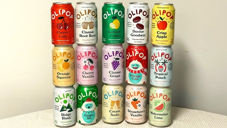 fifteen cans of Olipop stacked on a table