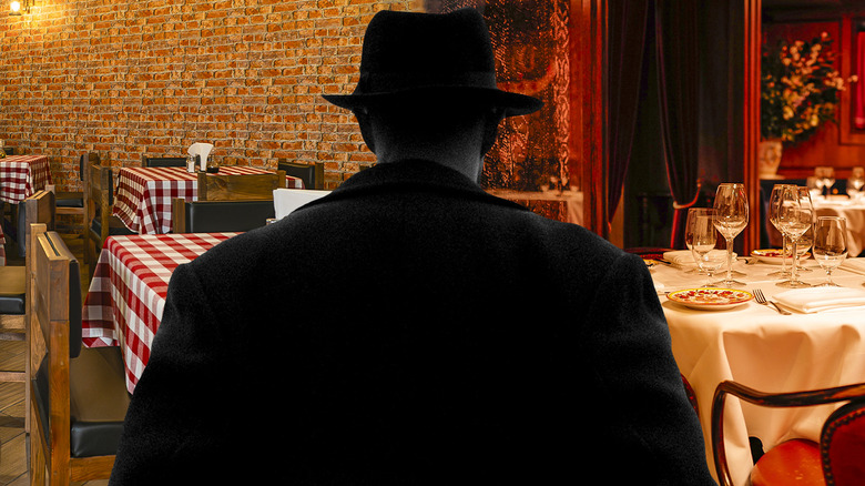 A mobster standing in front of new restaurants inside