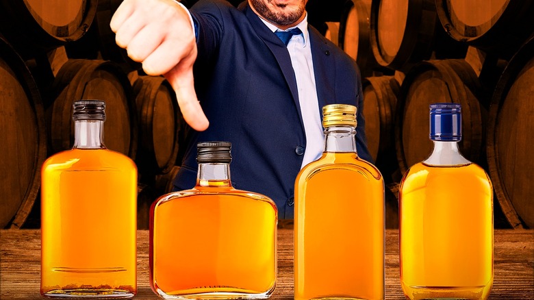 a thumbs down with bottles of bourbon