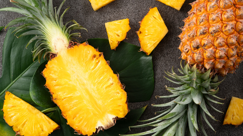 Pineapples being cut into pieces