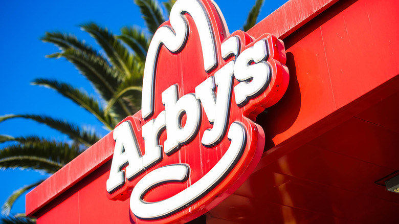 Arby's signage near a palm tree