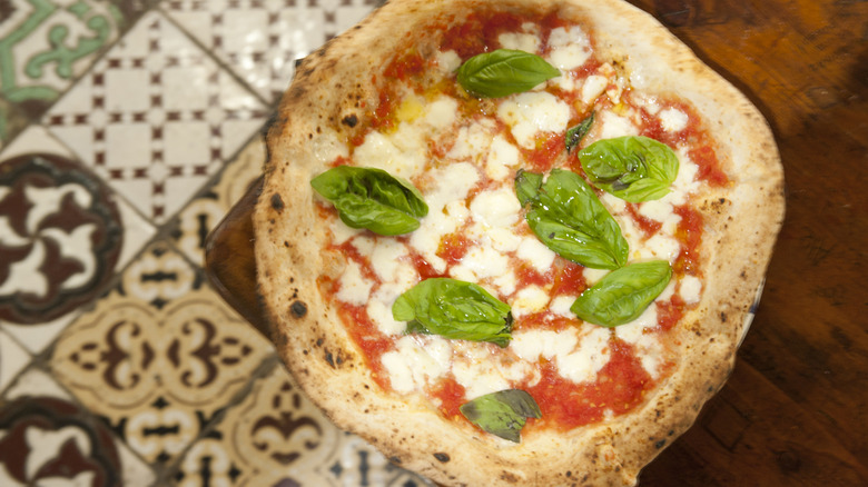 An unsliced margherita pizza seen from above.