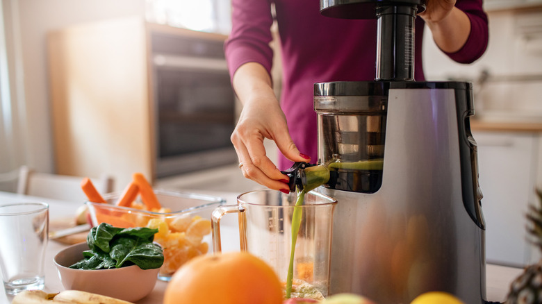 A woman making cold press juice