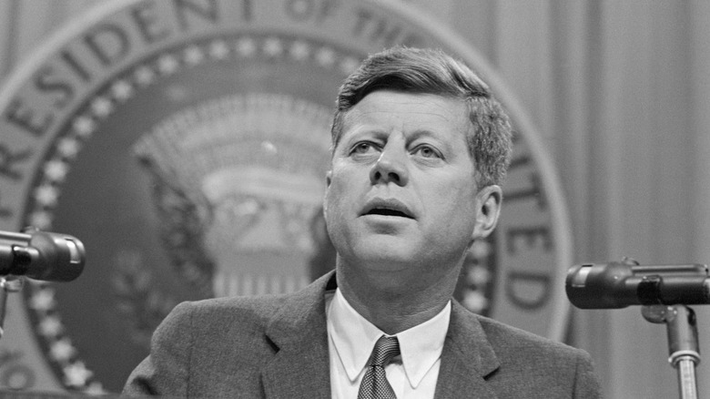President John F Kennedy making a speech in front of the presidential seal