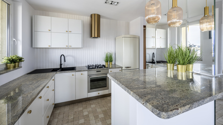Large open kitchen with white walls and grey stone countertops