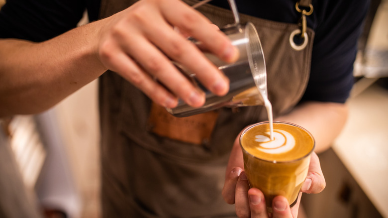 A barista pouring latte art